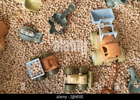 Ein moderner Kinder-Sandkasten mit Spielzeug. Sandkasten-Füllstoff in Form von kleinen Holzwürfeln. Stockfoto