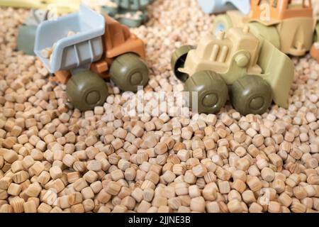 Ein moderner Kinder-Sandkasten mit Spielzeug. Sandkasten-Füllstoff in Form von kleinen Holzwürfeln. Stockfoto