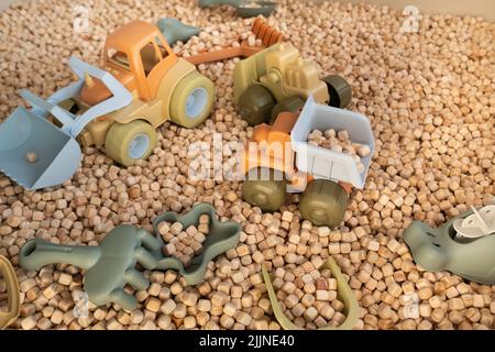 Ein moderner Kinder-Sandkasten mit Spielzeug. Sandkasten-Füllstoff in Form von kleinen Holzwürfeln. Stockfoto