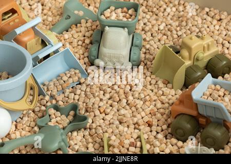 Ein moderner Kinder-Sandkasten mit Spielzeug. Sandkasten-Füllstoff in Form von kleinen Holzwürfeln. Stockfoto