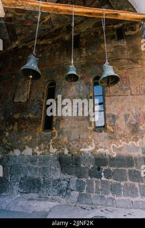 Eine vertikale Aufnahme von hängenden Glocken in einer alten Kirche in Georgien Stockfoto