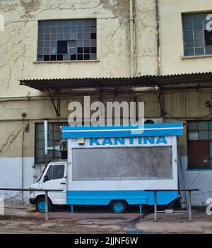 Eine vertikale Aufnahme eines blauen Lieferwagens, der als Kantine in einer Straße von Athen verwendet wurde Stockfoto