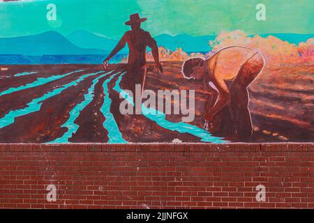 Wandgemälde mit der Darstellung des frühen Bauernlebens, gemalt auf Adobe Wall, Espanola, New Mexico, USA Stockfoto