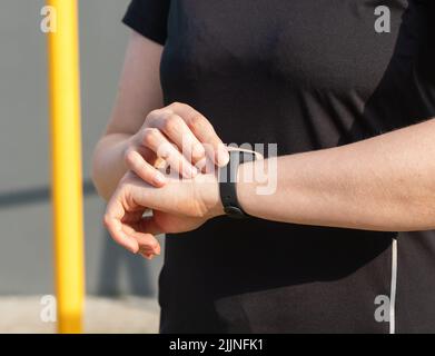 Sportler, der Fitness-Tracker während des Sporttrainings im Freien verwendet. Schrittanzahl, Herzfrequenz, Pulsüberwachung. Gesundes Lifestyle-Konzept. Hochwertige Fotos Stockfoto