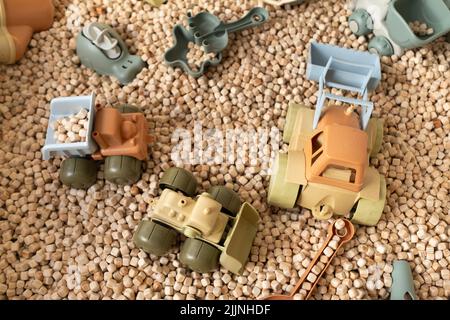 Ein moderner Kinder-Sandkasten mit Spielzeug. Sandkasten-Füllstoff in Form von kleinen Holzwürfeln. Stockfoto