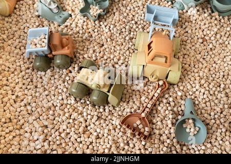 Ein moderner Kinder-Sandkasten mit Spielzeug. Sandkasten-Füllstoff in Form von kleinen Holzwürfeln. Stockfoto