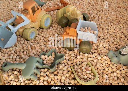 Ein moderner Kinder-Sandkasten mit Spielzeug. Sandkasten-Füllstoff in Form von kleinen Holzwürfeln. Stockfoto