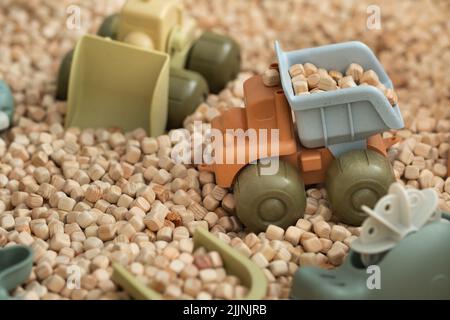 Ein moderner Kinder-Sandkasten mit Spielzeug. Sandkasten-Füllstoff in Form von kleinen Holzwürfeln. Stockfoto