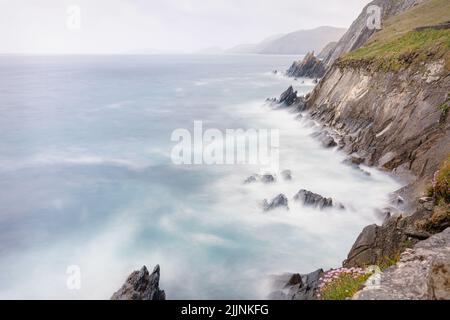 Langzeitbelichtung der Küste Klippen vom Coumeenoole Beach an der Südküste von Dunmore Head auf der Dingle Peninsular in der Grafschaft Kerry, Irland Stockfoto