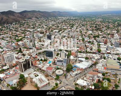 Allgemeine Luftaufnahme mit Drohne, der Stadt Carlos Paz, mit Bergen im Hintergrund an einem bewölkten Tag Stockfoto