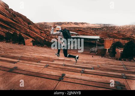 Ein Mann, der auf der Tribüne des Red Rocks Amphitheaters in Colorado, USA, läuft Stockfoto