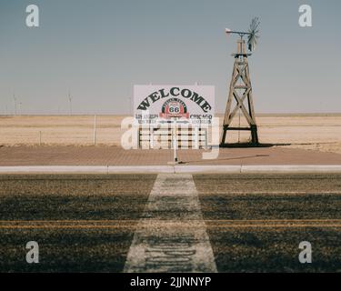 Das touristische Mittelpunktschild entlang der Route 66 Autobahn an einem sonnigen Tag in Adrian, Texas, USA Stockfoto