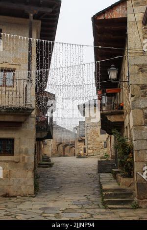 Eine vertikale Aufnahme von hängenden Lichterketten in einer Gasse in Puebla de Sanabria, Spanien Stockfoto