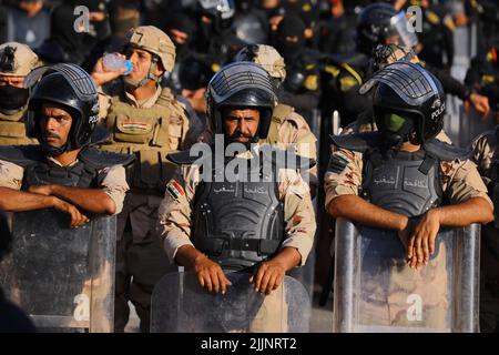 Bagdad, Irak. 27.. Juli 2022. Irakische Sicherheitskräfte stehen während einer Demonstration von Anhängern des einflussreichen schiitischen Geistlichen Moqtada al-Sadr vor der befestigten grünen Zone von Bagdad, in der sich das parlament und viele Botschaften befinden, Wache. Demonstranten stürmten das parlamentsgebäude in Bagdad, um während einer monatelangen Sackgasse im Land politische Reformen zu fordern. Quelle: Ameer Al-Mohammedawi/dpa/Alamy Live News Stockfoto