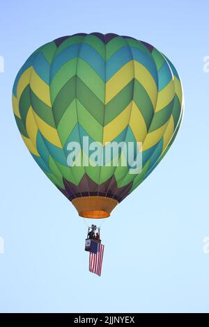 Eine vertikale Aufnahme eines Luftballons, der die amerikanische Flagge in der Luft schwenkt, das Ballon von Carolina. Stockfoto