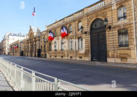 Blick auf das Eingangstor des Elysee-Palastes mit Nationalflaggen. Elysee Palace - offizielle Residenz des Präsidenten der Französischen Republik seit Stockfoto