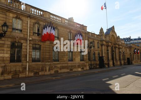 Blick auf das Eingangstor des Elysee-Palastes mit Nationalflaggen. Elysee Palace - offizielle Residenz des Präsidenten der Französischen Republik seit Stockfoto