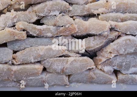 Stapel gesalzener Kabeljaufiletten auf der Theke eines lokalen Basars. Stockfoto