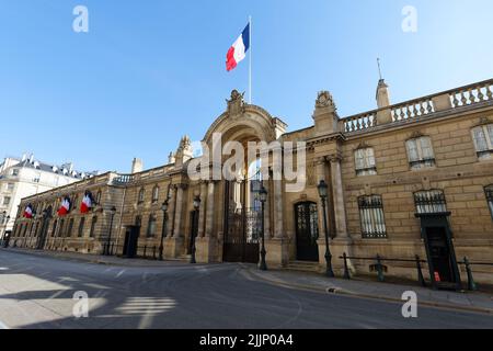 Blick auf das Eingangstor des Elysee-Palastes mit Nationalflaggen. Elysee Palace - offizielle Residenz des Präsidenten der Französischen Republik seit Stockfoto