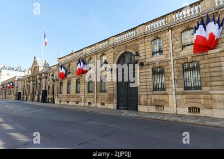 Blick auf das Eingangstor des Elysee-Palastes mit Nationalflaggen. Elysee Palace - offizielle Residenz des Präsidenten der Französischen Republik seit Stockfoto