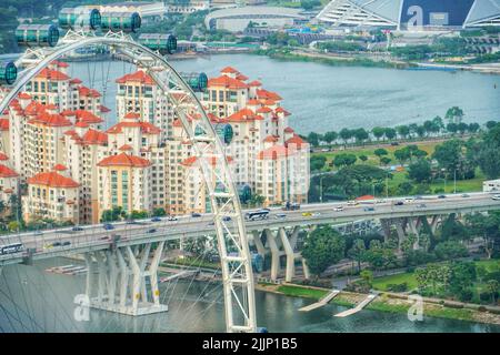 Eine Luftaufnahme des Riesenrads am Marina Bay Garden in Singapur, umgeben von Gebäuden und Bäumen Stockfoto