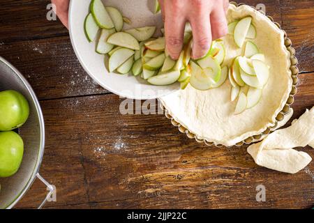 Mann kocht hausgemachten französischen Apfelkuchen Holztisch Stockfoto