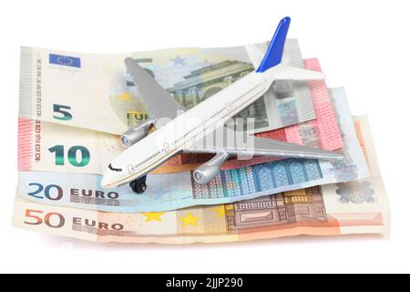 Ein Flugzeug-Spielzeug auf Euro-Banknoten isoliert auf weißem Hintergrund - sparen Sie Geld für Reisen Stockfoto