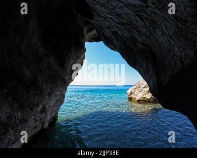 Blick von innen auf eine Höhle auf ein wunderschönes Meer und eine Felsstruktur Stockfoto