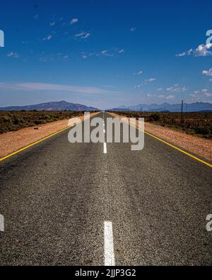 Eine vertikale Aufnahme einer leeren Straße auf einer sonnigen Tag Stockfoto