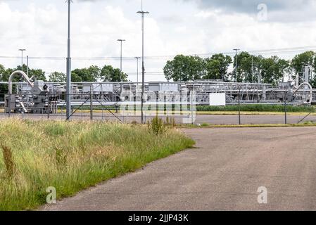 Bohrlochköpfe und Pipelines an einem Erdgasförderstandort auf dem Land. Groninger Gasfeld. Stockfoto