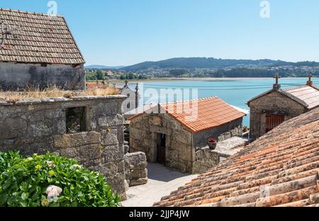 Altes Viertel mit kleinen Steingebäuden in der Küstenstadt Combarro in der Region Galicien, Spanien Stockfoto