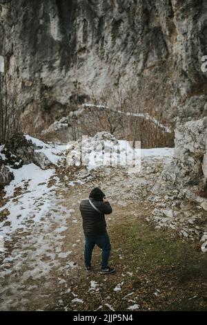 Ein junger Tourist, der im Winter mit seiner Kamera fotografiert Stockfoto