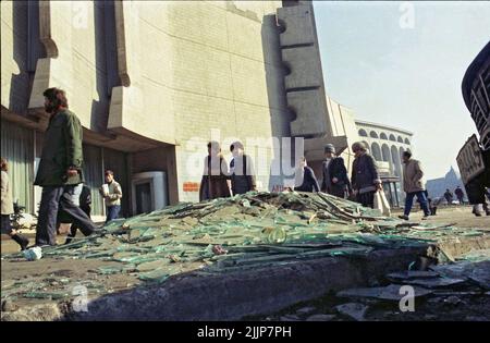 Bukarest, Rumänien, Januar 1989. Menschen, die an zerbrochenem Glas und Trümmern auf dem Universitätsplatz am Intercontinental Hotel vorbeikommen, Tage nach der antikommunistischen Revolution im Dezember 1989. Stockfoto