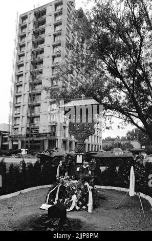 Bukarest, Rumänien, Januar 1990. Blumen, die auf dem Gelände des rumänischen öffentlichen Fernsehsenders an ein Kreuz gelegt wurden, zum Gedenken an die Opfer der antikommunistischen Revolution in Rumänien vom Dezember 1989. Stockfoto