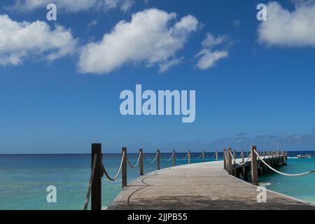 A perspective shot of a wooden walking bridge on the sea. Stockfoto