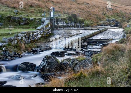 Eine faszinierende Szene von fließendem majestätischem Wasser mit Felsen in den Devonport Leat mit Bäumen Stockfoto