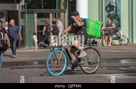 Wien, Österreich - 13. Juni 2022: Fahrradkurier liefert Lebensmittel an einen Kunden. Stockfoto