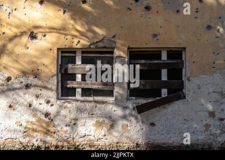 Die alten hölzernen kaputten Schienen der Kellerfenster in Maglaj, Bosnien Stockfoto