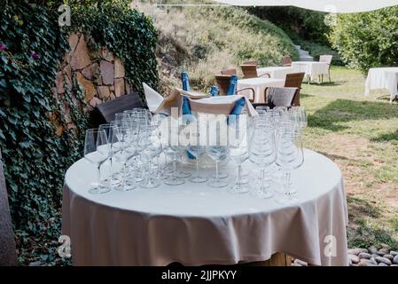 Ein wunderschön dekorierter Hochzeitstisch mit Gläsern und Getränken im Garten Stockfoto