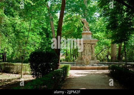 Ein Brunnen mit einer schönen Skulptur und der Wald in Frühlingsfarben im Park Aranjuez, Madrid, Spanien Stockfoto