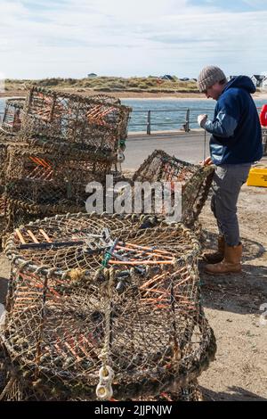 England, Dorset, Christchurch, Mudeford, Fisherman repariert Krabben- und Hummer-Netze Stockfoto