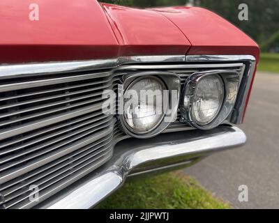 Eine Nahaufnahme der Scheinwerfer eines roten Oldtimers Stockfoto