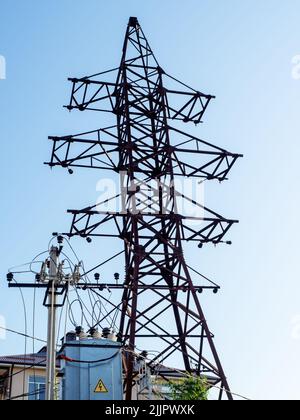 Strommast in der Nähe des Transformatorkastens. Alter Strommast. Elektrischer Mast ohne Kabel. Stockfoto