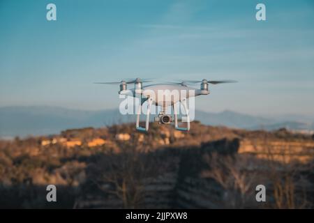 Eine große weiße Drohne in schwebenden mit Konstruktionen in unscharfem Hintergrund in Rom, Italien Stockfoto