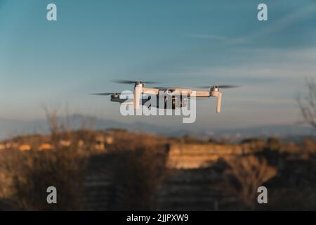Eine große weiße Drohne im Schwebeflug Stockfoto