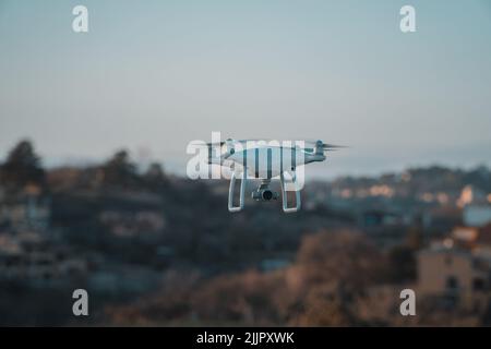 Eine große weiße Drohne im Schwebeflug Stockfoto