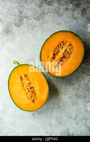 Ansicht von oben auf zwei Hälften einer Melone auf einem Tisch Stockfoto