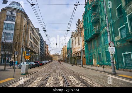 Eine Straße mit Zebrastreifen und einem alten Gebäude, das im Stadtzentrum von Posen renoviert wird Stockfoto