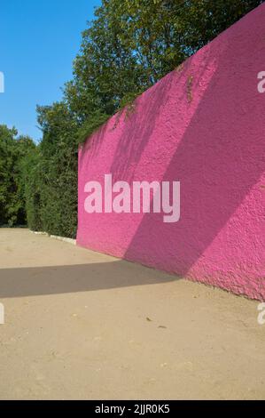 Luis Barragans Cuadra San Cristobal rosa Wand, endemische Vegetation und sandiger Boden im Hintergrund Stockfoto