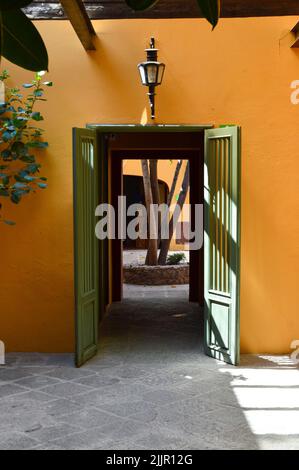 Altes Haus, orange gestrichen, mit Holztür in grün lackiert Stockfoto